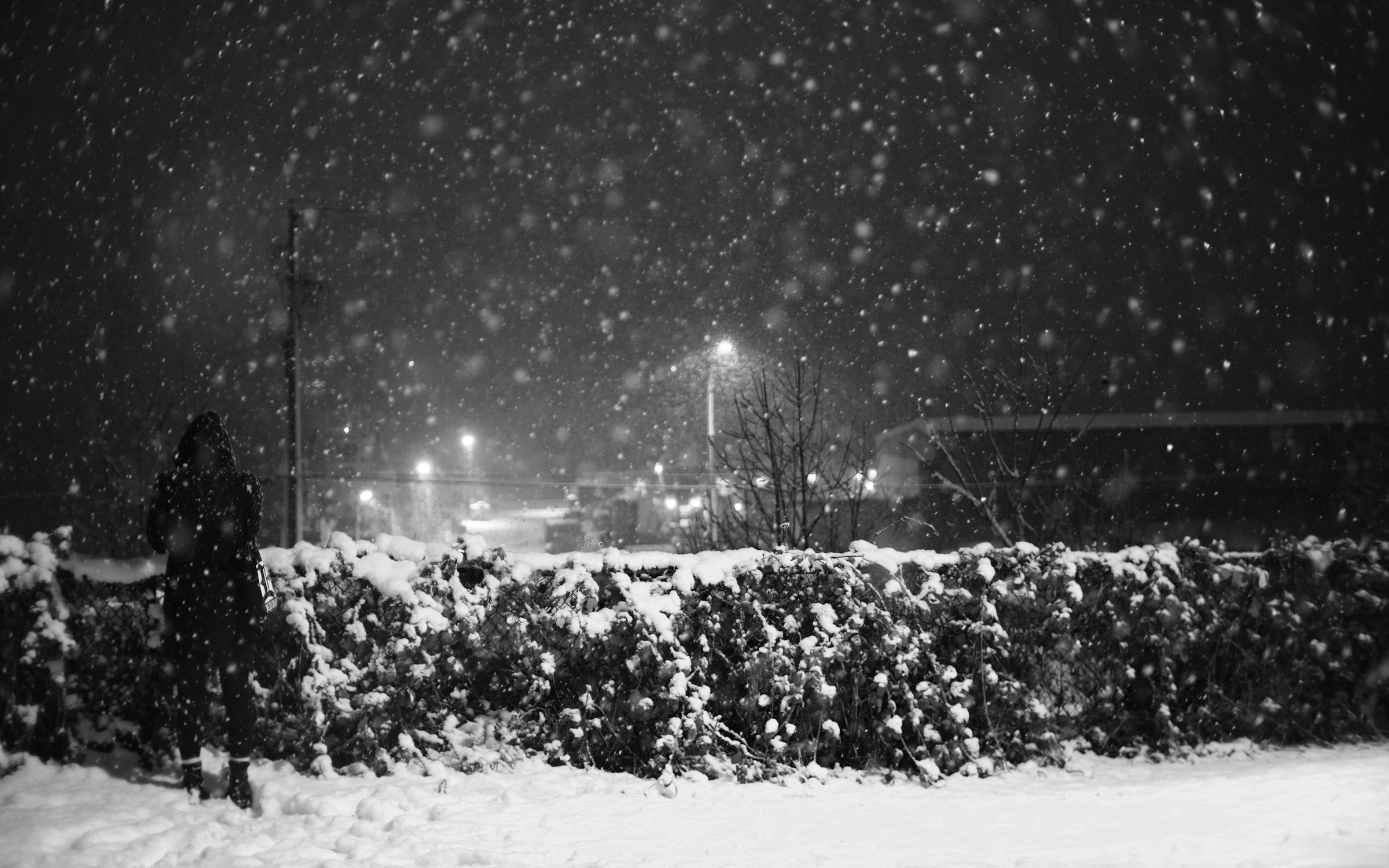 Heavy snowfall under street lights at night