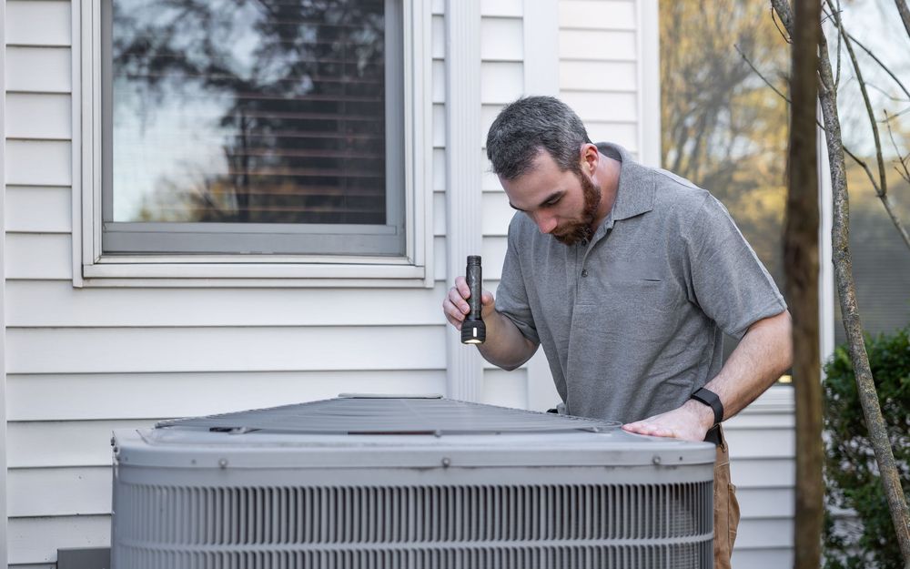 Technician inspecting an outdoor air conditioning unit