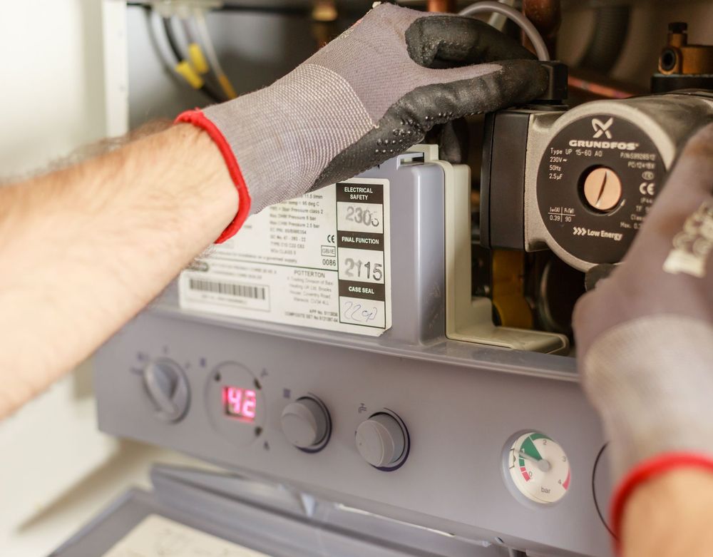 Gloved hands adjusting the controls of a heating unit