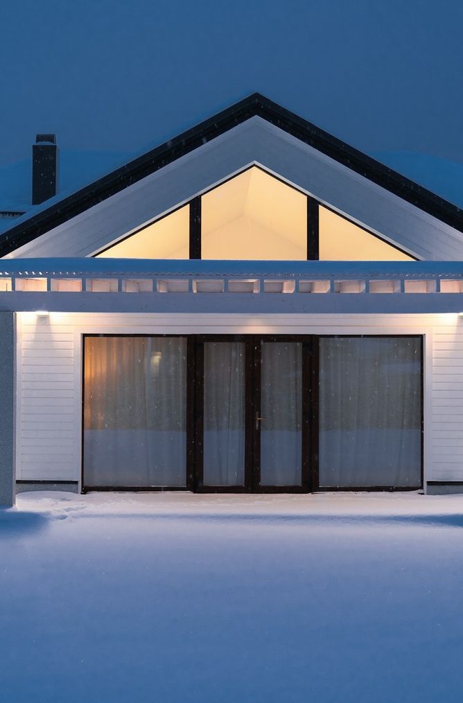 A warm, lit home on a snowy winter evening